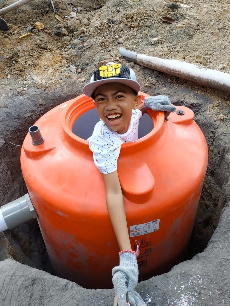 A boy in a septic tank for a Safe Water Garden system during installation